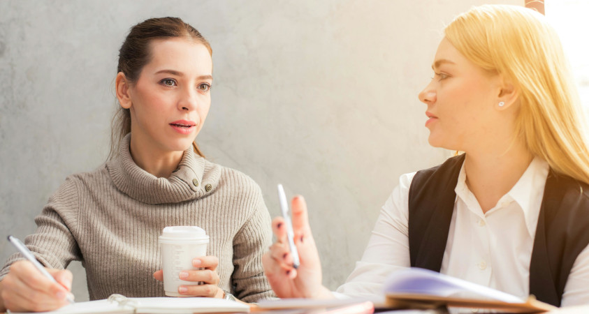 Zwei Frauen sitzen zusammen und lernen