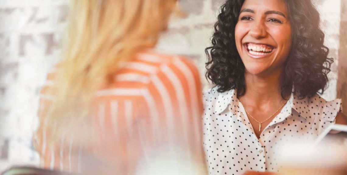 Zwei Frauen unterhalten sich fröhlich